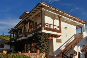 a large white house with a balcony at Casa de Campo Hotel & Spa in Villa de Leyva