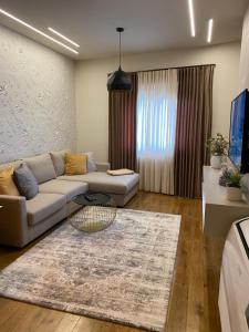 uma sala de estar com um sofá e uma mesa em Comfort Apartament 21 em Durrës