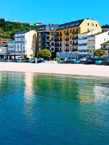 a view of a beach with buildings and the water at Beachport in Viveiro