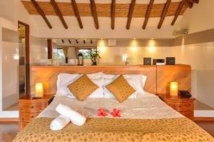 a bedroom with a bed with two red flowers on it at Casa de Campo Hotel & Spa in Villa de Leyva