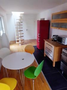 cocina con mesa, sillas y nevera roja en Sonnen-Apartment en Bad Honnef am Rhein