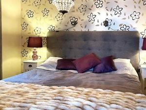 a bedroom with a large bed with purple pillows at Holiday home SÖDERKÖPING II in Söderköping