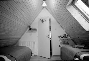 a attic room with two beds and a window at Zenith A-Frame Straja in Lupeni