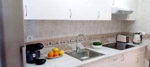 a kitchen with a sink and a bowl of oranges at Centro Playa de Sabinillas Manilva in San Luis de Sabinillas +22 photos
