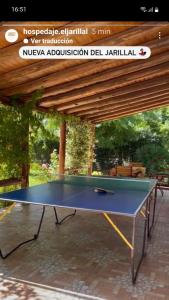 a ping pong table sitting under a wooden pergola at Casa Rural entre Bodegas y Viñedos ' El Jarillal" in La Consulta