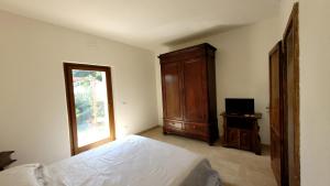 een slaapkamer met een bed, een dressoir en een raam bij Agriturismo Poggio la Lodola in Massa Marittima
