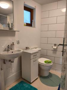 ein weißes Bad mit einem WC und einem Waschbecken in der Unterkunft Ferienwohnung TAL-ECK in Bad Teinach-Zavelstein