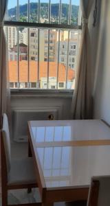 una mesa y una ventana con vistas a la ciudad en Apartamento encantador com vaga de garagem, en Río de Janeiro