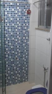 bagno con doccia piastrellata blu e servizi igienici di Apartamento encantador com vaga de garagem a Rio de Janeiro