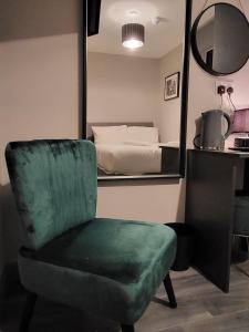 ein Schlafzimmer mit einem grünen Stuhl und einem Bett in der Unterkunft Phoenix Pods in Liverpool