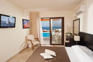 a bedroom with a bed and a view of the ocean at Miramare Resort & Spa in Agios Nikolaos