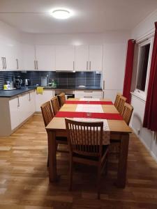 a kitchen with a table and chairs in a room at FeelHome apartment In Tromsdalen in Tromsø