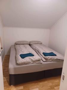 a bed in a room with two blue pillows on it at FeelHome apartment In Tromsdalen in Tromsø