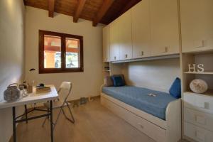 a bedroom with a bunk bed with a desk and a table at Casa Mediterraneo Lu Bagnu Castelsardo in Castelsardo