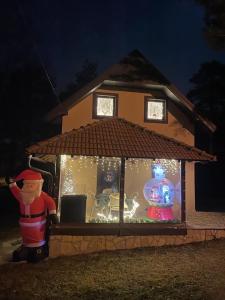 une maison couverte de lumières de Noël dans une cour dans l'établissement Apartman Toki, à Divčibare
