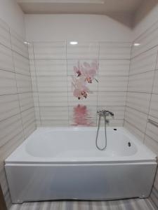 a white bath tub with a flower on the wall at Apartman Vranje in Vranje +22 photos