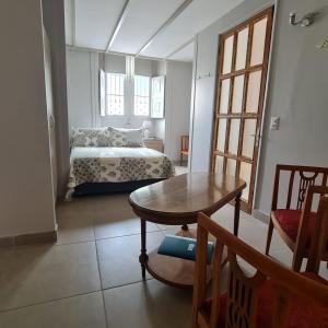 Casa Hostal Paso por La Serena في لا سيرينا: غرفة نوم بسرير وطاولة في غرفة