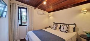1 dormitorio con cama y ventana en Casinha D&K - Itaguá, en Ubatuba