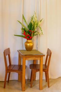una mesa con un jarrón con dos sillas en Pariri Suites, en Trancoso