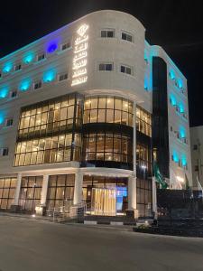 a large building with a sign on it at night at منــازل الماسة للشقق المخدومة عنيزة in Unayzah