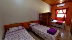a small bedroom with two beds and a window at Morada Caminho do Mar in Praia do Rosa