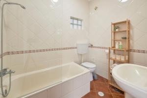 ein Badezimmer mit einer Badewanne, einem WC und einem Waschbecken in der Unterkunft Central & Sunny 2BR Apt Near Beach, By TimeCooler in Setúbal