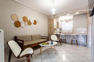 un salon avec un canapé et des chaises et une cuisine dans l'établissement Kalamata Old City - Minimal Urban Retreat, à Kalamata