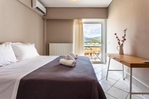 a bedroom with a bed with a table and a window at Kalamata Old City - Minimal Urban Retreat in Kalamata