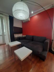 ein Wohnzimmer mit einem Sofa und einer roten Wand in der Unterkunft Heart Of City Center Flat in Chişinău