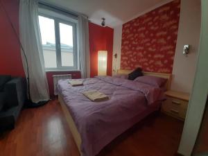 ein Schlafzimmer mit einem Bett mit violetter Bettwäsche und einem Fenster in der Unterkunft Heart Of City Center Flat in Chişinău