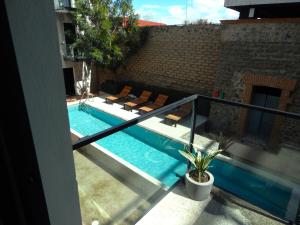 a balcony with a swimming pool with lounge chairs at Hotel Tila in Cholula