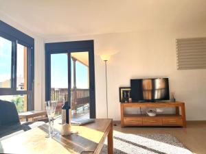 a living room with a couch and a tv on a table at Beautiful 100m apartment in Palm Mar in Palm-mar