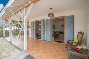 een veranda van een huis met blauwe glazen schuifdeuren bij Villa Surelles - 3 chambres - piscine - Le Diamant in Le Diamant