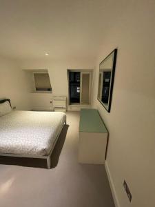 a bedroom with a bed and a table in it at Oxford Street Apartment in London