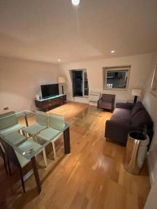 a living room with a couch and a table at Oxford Street Apartment in London