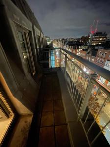 a balcony with a view of a city at night at Oxford Street Apartment in London