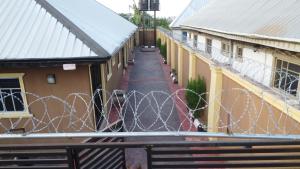 a fence with a barbed wire in the middle of two buildings at Living Green APARTMENTS AIRPORT PICK UP in Benin City