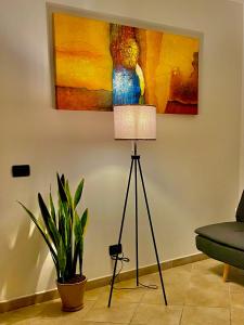 a lamp in a living room with a painting on the wall at La casetta di Giulio II in Ostia Antica