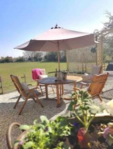 a table and chairs with an umbrella in a garden at Luxury Barn in North Scarle in North Scarle