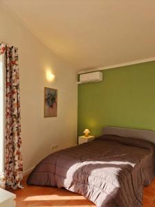 1 dormitorio con 1 cama con pared verde en LA TERRAZZA HOME, en Caserta