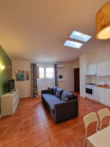 Una sala de estar con un sofá y una cocina. en LA TERRAZZA HOME, en Caserta