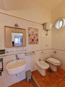 y baño con lavabo, aseo y espejo. en LA TERRAZZA HOME, en Caserta