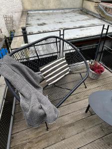 un banc avec une couverture assise sur une terrasse dans l'établissement escapade_Binchoise, à Binche