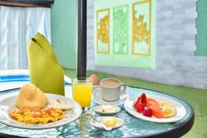 a table with two plates of breakfast food and a cup of coffee at HOTEL EVOCACIÓN in Buga