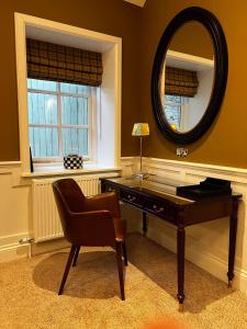 a desk with a chair and a mirror in a room at The Wrea Head Hall Country House Hotel & Restaurant in Scarborough