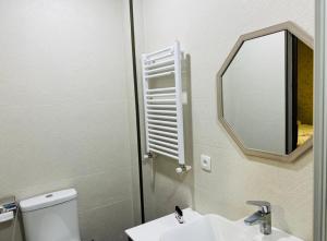 y baño con aseo, lavabo y espejo. en Green Hotel ANG, en Telavi