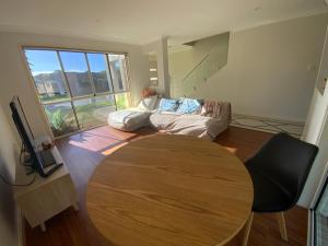 sala de estar con mesa y sofá en Shared house with other guests near shopping center and theme parks en Gold Coast