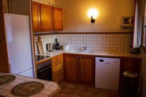 uma cozinha com armários de madeira e um frigorífico branco em Chalet Wallis, Wifi, Garage, Proche des pistes em Isola
