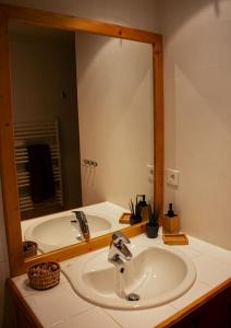 a bathroom with a sink and a large mirror at Chalet Wallis, Wifi, Garage, Proche des pistes in Isola