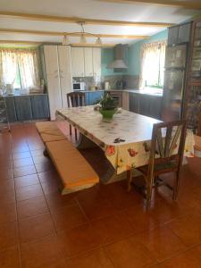 una cocina con una gran mesa de madera y sillas en Villa Bimba, alojamiento con piscina y barbacoa, en Caldas de Reis